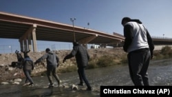 Migrantes cruzan el río Grande hacia la frontera entre México y Estados Unidos, el lunes 19 de diciembre de 2022, en Ciudad Juárez, México. 