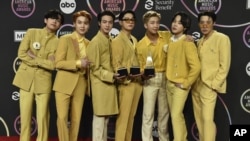 BTS posa en la sala de prensa con los premios al dúo o grupo pop favorito, canción pop favorita por "Butter" y artista del año en los American Music Awards el domingo 21 de noviembre de 2021 en el Teatro Microsoft de Los Ángeles. (Foto de Jordan Strauss/Invision/AP)