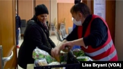 Zohra, a la izquierda, recibe alimentos gratis en el Ejército de Salvación en París.