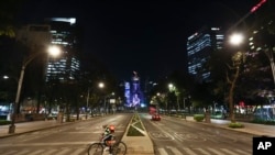 Un repartidor de alimentos cruza la Avenida Reforma, en la Ciudad de México, el viernes 27 de marzo de 2020. 