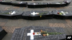 ARCHIVO - Flores sobre ataúdes simbólicos que representan a las víctimas del conflicto civil de Colombia en la plaza Bolívar en Bogotá, en abril de 2018.
