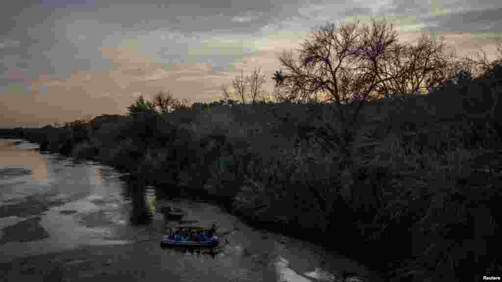 A través del Río Grande, un contrabandista usa una balsa para transportar de México a Estados Unidos a familias de migrantes.
