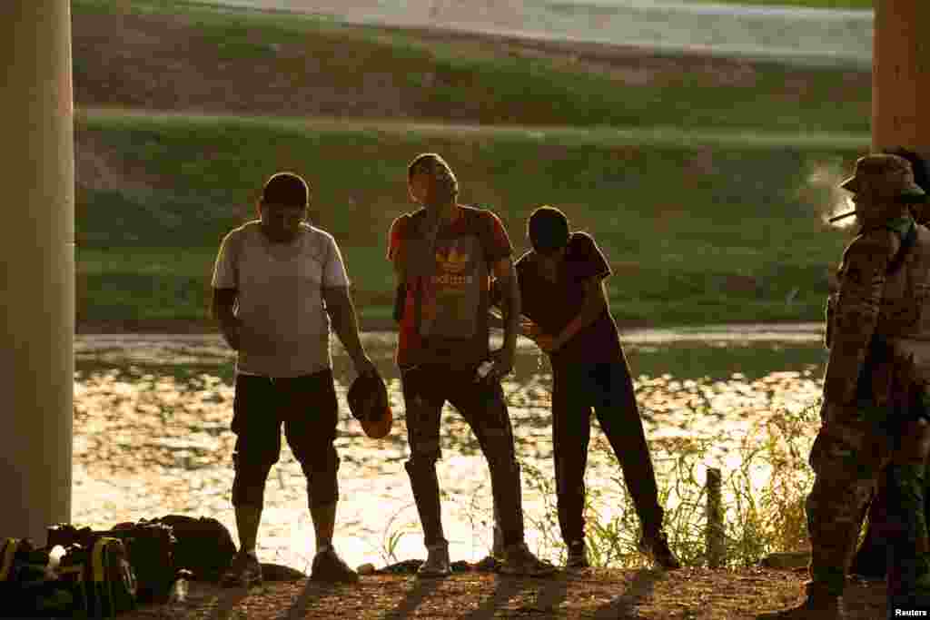 Después de cruzar el Río Grande, migrantes que buscan asilo en Estados Unidos esperan ser transportados por agentes de Aduanas y Protección Fronteriza de EEUU.