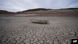 Un bote hundido se asienta sobre tierra agrietada a cientos de pies de la costa del lago Mead, cerca de Boulder City, Nevada. Otro cuerpo ha aparecido en el lago Mead. (Foto AP/John Locher, archivo)