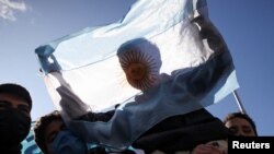 Un joven sostiene una bandera argentina mientras los trabajadores desempleados e informales marchan en protesta contra las políticas económicas del gobierno y en demanda de mejores condiciones de trabajo, en Buenos Aires, Argentina, 28 de julio de 2022. REUTERS/Cristina Sille