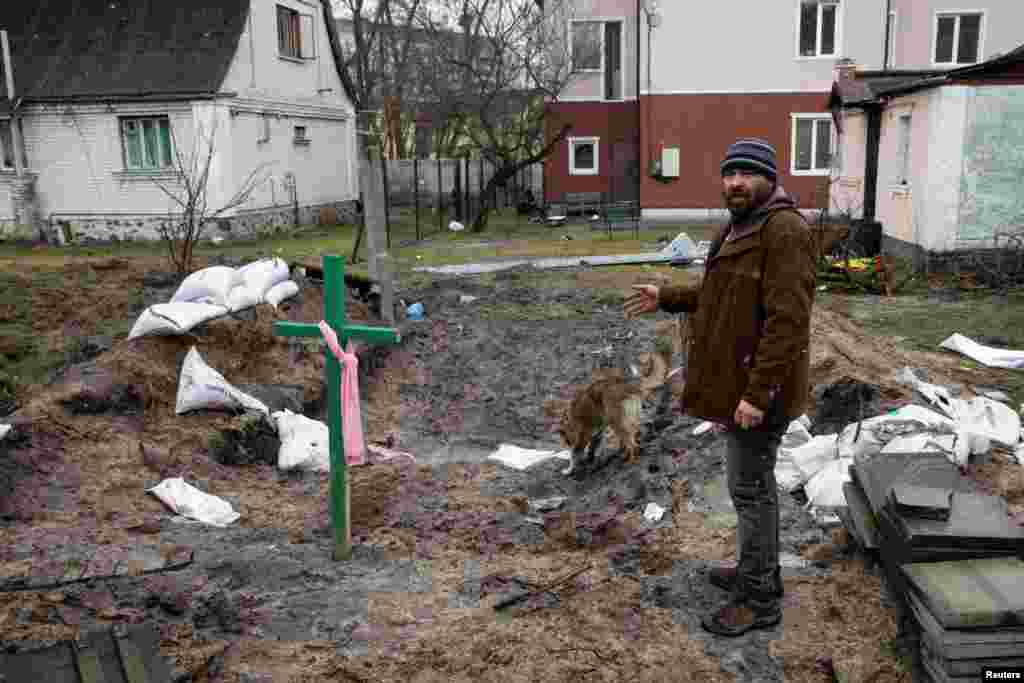 Un hombre junto a una tumba, en medio de la invasión de Rusia a Ucrania, en Bucha, Ucrania, el 3 de abril de 2022.