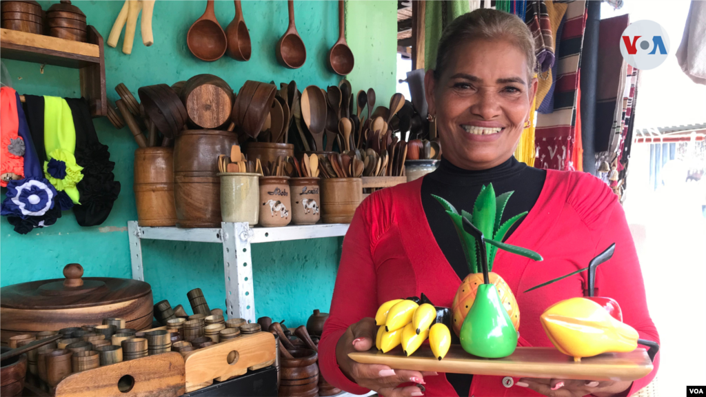 La artesana María Medina muestra algunas de las piezas talladas en madera que fabrica junto a su familia.