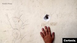 Agujero de bala en una pared situada en un lugar donde juegan niños del Bajo Aguán, en Honduras.