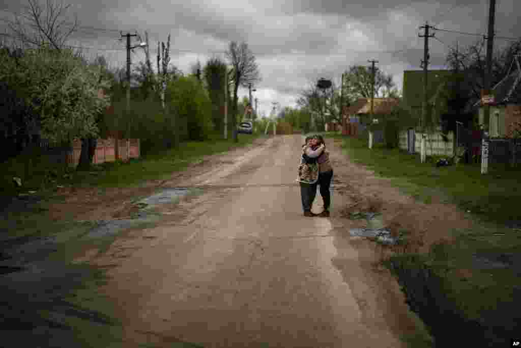Tetyana Boikiv, de 52 años, a la derecha, abraza a su vecina Svitlana Pryimachenko, de 48 años, durante el funeral de su marido Mykola Moroz, de 47 años, en el pueblo de Ozera, cerca de Bucha, Ucrania, el martes 26 de abril de 2022. Mykola fue capturado por soldados rusos en su casa de Ozera el 13 de marzo y llevado durante varias semanas a un lugar desconocido. Más tarde fue encontrado a unos 15 kilómetros de su casa, muerto con impactos de bala. (AP Foto/Emilio Morenatti)