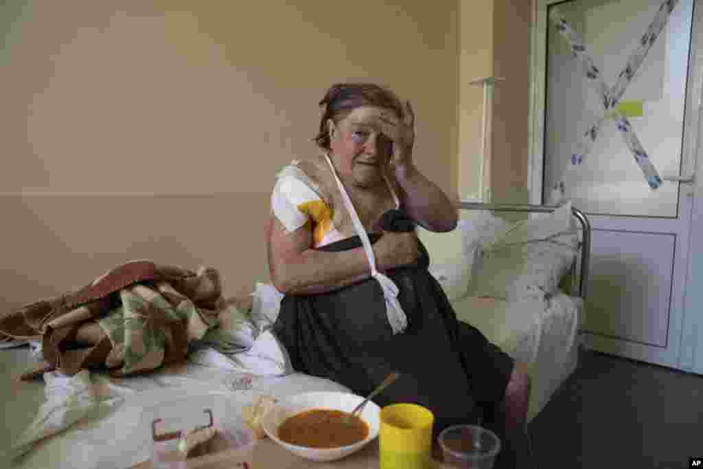 Tamara Oliynyk, de 62 años, se sienta en una cama después de una operación quirúrgica debido a las heridas producidas por un bombardeo en el pueblo de Shandrigolovo, mientras se recupera en un hospital de Kramatorsk, en el este de Ucrania, el martes 26 de abril de 2022. (AP Foto/Evgeniy Maloletka)