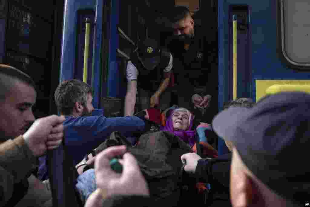 Socorristas ayudan a una anciana discapacitada a entrar en un tren de evacuación en Pokrovsk, en el este de Ucrania, el martes 26 de abril de 2022. (AP Foto/Evgeniy Maloletka)