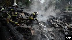Los bomberos rocían los escombros de un complejo de restaurantes destruido por un ataque con misiles en Kharkiv, la segunda ciudad ucraniana más grande, el 4 de septiembre de 2022, en medio de la invasión rusa a Ucrania.