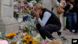 Un doliente está abrumado por la emoción mientras presenta sus respetos a las puertas del Palacio de Buckingham en Londres, el viernes 9 de septiembre de 2022.