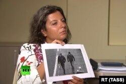 RUSSIA -- RT Editor-in-Chief Margarita Simonyan shows an image of two men during an interview with Aleksandr Petrov and Ruslan Boshirov, who are suspected by the British authorities of poisoning former GRU officer Sergei Skripal and his daughter Yulia.