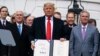 Президент США Дональд Трамп демонстрирует только что подписанное им соглашение о торговле с Канадой и Мексикой. 29 января 2020 года