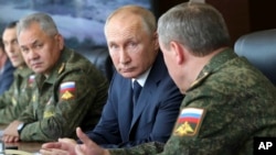  El presidente ruso, Vladimir Putin (centro) y el ministro de Defensa ruso, Sergei Shoigu (izq.), supervisan los ejercicios estratégicos de comando y personal Kavkaz-2020 en Kapustin Yar, Rusia, en septiembre de 2020. [Foto de archivo]