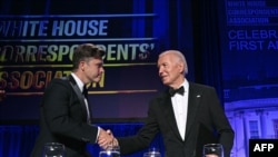 El presidente estadounidense Joe Biden saluda al comediante estadounidense Colin Jost (R) durante la cena de la Asociación de Corresponsales de la Casa Blanca (WHCA) en el Washington Hilton, en Washington, DC, el 27 de abril de 2024