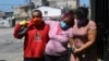 Mariela Jácome (derecha) ayuda a su madre Catherine Quiñonez (centro), de camino al hospital en Guayaquil, Ecuador. La mujer presentó síntomas de coronavirius el 16 de abril de 2020.