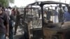 Residents survey vehicles damaged after a bomb blast at a primary school in Maiduguri, the capital of Nigeria's Borno state, February 29, 2012. 