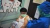 Seorang tenaga medis menyuntikan vaksin virus corona kepada seorang relawan dalam uji klinis vaksin di Bandung, Jawa Barat, 14 Agustus 2020. 