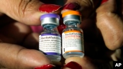 ARCHIVO - Una enfermera sostiene unos frascos de la vacuna contra COVID-19 de Pfizer, el martes 8 de febrero de 2022, en Jackson, Mississippi. (AP Foto/Rogelio V. Solis, Archivo)