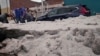 La gente quita el hielo grueso de una calle después de una granizada en medio de una ola de calor, en Puebla, México, el 24 de mayo de 2024.