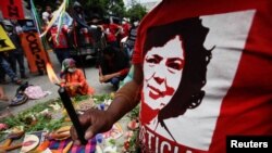 Un manifestante sostiene una vela mientras protesta frente a la Corte Suprema durante el juicio de Roberto David Castillo, ex alto ejecutivo de Desarrollos Energéticos (DESA), quien fue sentenciado a más de 22 años por su papel en el asesinato de ambientalistas en 2016. 
