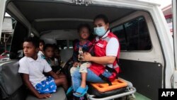 Miembros de la Defensa Civil ayudan a evacuar a los niños en el puerto de Blufields antes de la llegada de la tormenta tropical Bonnie al pueblo de Bluefields, Nicaragua, el 1 de julio de 2022.