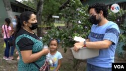 Joel García, un voluntario que presta sus servicios sanitarios en la comunidad de San Nicolás, en Honduras, le entrega una medicina a una mujer que no puede acceder a una mínima asistencia médica. 