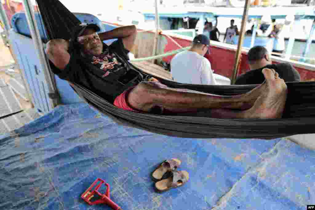 Un pescador descansa en una hamaca a bordo de su bote en el puerto antes de la llegada de la tormenta tropical Bonnie a Nicaragua.