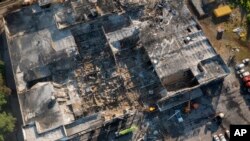 Bomberos del Servicio Estatal de Emergencias de Ucrania trabajan para retirar los escombros de un centro comercial quemado después de un ataque con cohetes en Kremenchuk, Ucrania, el martes 28 de junio de 2022. (Foto AP/Efrem Lukatsky)