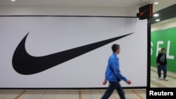 La gente pasa frente a una tienda cerrada del minorista de artículos deportivos Nike en un centro comercial en San Petersburgo, Rusia, el 25 de mayo de 2022.