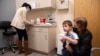 Ilana Diener bersama putranya, Hudson (3 tahun), menunggu untuk menerima suntikan vaksin COVID-19 produksi Moderna di kota Commack, New York (foto: dok).