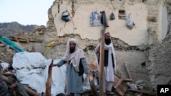 Hombres afganos revisan los escombros después de un terremoto, en la aldea de Gayan, provincia de Paktika, Afganistán, el 23 de junio de 2022.