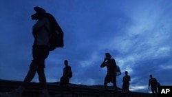 Migrantes caminan hacia el norte por la carretera hacia la salida a Huixtla, estado de Chiapas, México, al amanecer del jueves 9 de junio de 2022. 
