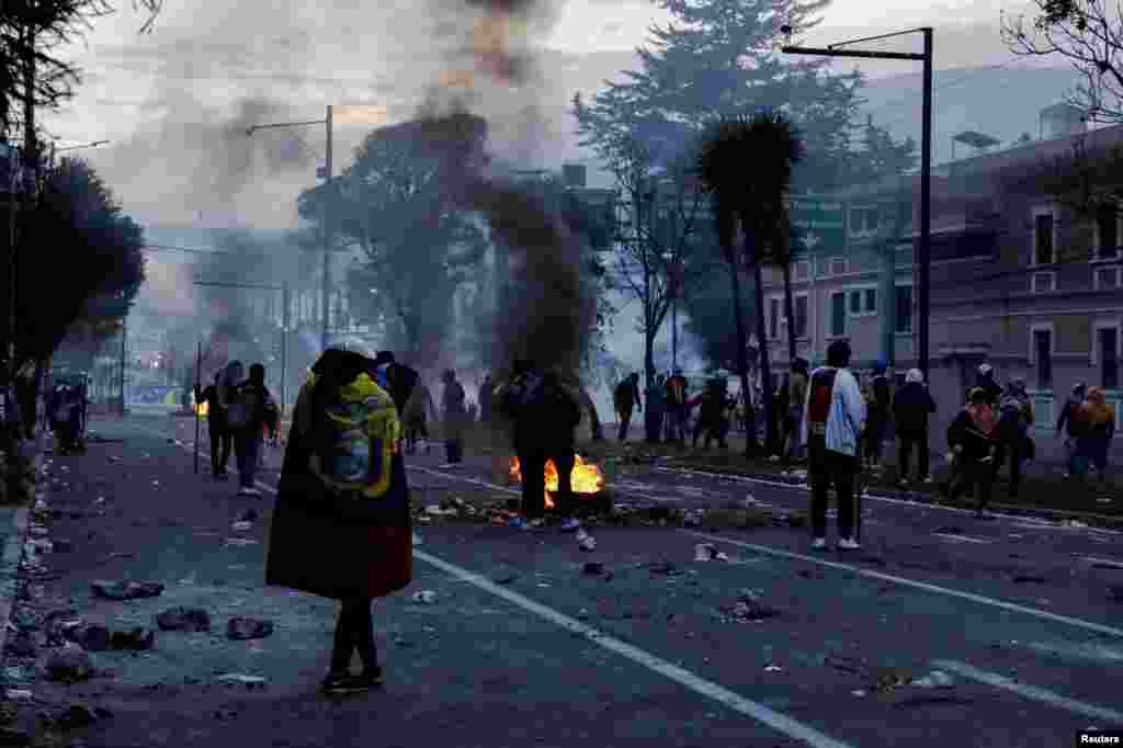 Manifestantes indígenas se reúnen cerca de un bloqueo de carretera en llamas.&nbsp;