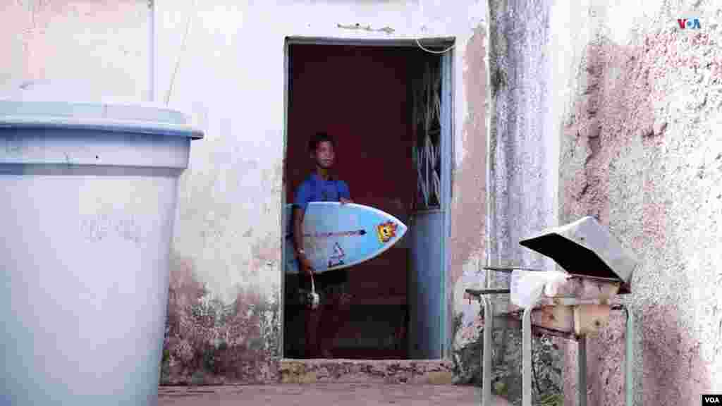 Tabla en mano, Yandel Merentes se alista para conquistar las olas del día en las majestuosas playas de Anare, Venezuela. [Foto: VOA / Nicole Kolster].
