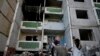 Niños se paran frente a un edificio destruido por los ataques en Chernihiv, Ucrania, el domingo 19 de junio de 2022.