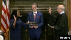 La jueza Ketanji Brown Jackson toma juramento judicial de su cargo a la Corte Suprema de EEUU ante el juez Stephen Breyer, a quien reemplaza debido a su retiro, mientras el esposo de Jackson, Patrick Jackson, sostiene la Biblia, el 30 de junio de 2022.