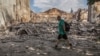 ARCHIVO - Un residente local camina frente a un edificio destruido por un ataque militar, en Lysychansk, región de Luhansk, Ucrania, el 17 de junio de 2022.