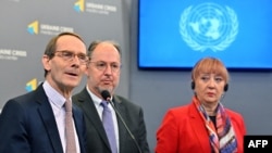 El presidente de la Comisión Internacional Independiente de Investigación sobre Ucrania, Erik Mose (izq.), flanqueado por los miembros de la comisión Pablo de Greiff (centro) y Jasminka Dzumhur dan una conferencia de prensa en Kiev, el 15 de junio de 2022.