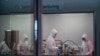 Scientists re-enact the calibration procedure of equipment at an Afrigen Biologics and Vaccines facility in Cape Town, South Africa, Tuesday Oct. 19, 2021.