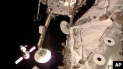 A NASA image taken from video shows the Russian Soyuz spacecraft (L), ferrying three crew members, approaching the International Space Station, March 27, 2014.