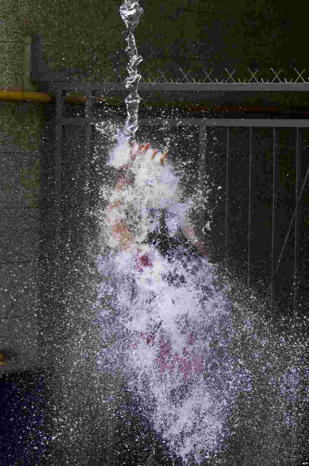 A woman is drenched with water splashed from an office in Montevideo&#39;s old district, Uruguay, as a way of celebrating the end of the year.