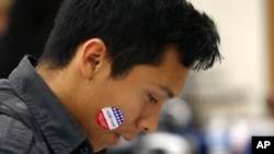 ARCHIVO - En esta fotografía del 5 de marzo de 2020, Ángel Tapia muestra su calcomanía "Yo voté hoy" mientras los estudiantes participan en la elección de participación presupuestaria en la escuela secundaria Maryvale en Phoenix.