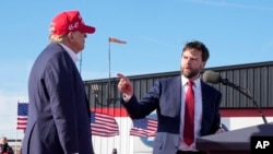 ARCHIVO - El senador J.D. Vance, republicano por Ohio, señala al candidato presidencial republicano, el expresidente Donald Trump, en un mitin de campaña, el 16 de marzo de 2024, en Vandalia, Ohio. 