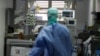 Un médecin surveille un patient atteint du coronavirus en traitement dans l'unité de soins intensifs de l'hôpital de Brescia en Italie, le 16 mars 2020. (Photo AP)