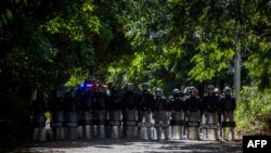 Una línea de policías antidisturbios permanece afuera de las oficinas del periódico El Confidencial en Managua el 14 de diciembre de 2020.