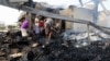 Yemeni men inspect damage at a factory allegedly targeted by Saudi-led coalition airstrikes in the Red Sea town of Hodeidah, July 27, 2018. 
