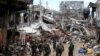 Government soldiers stand in front of damaged houses and buildings in Marawi city, Philippines, Oct. 25, 2017.